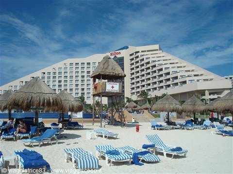 Hilton hotel beach in Cancún, thatched umbrellas, striped loungers and lifeguard tower