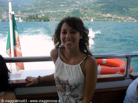 Smiling woman on a boat on Lake Como, white wake and Italian flag