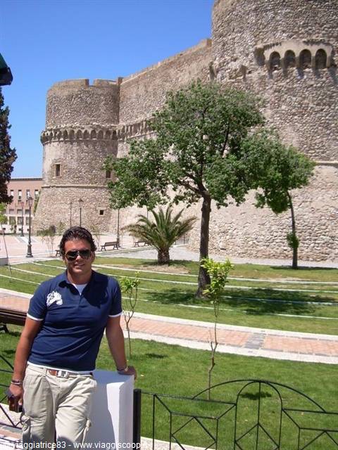 Tourist in sunglasses in front of the castle's stone towers