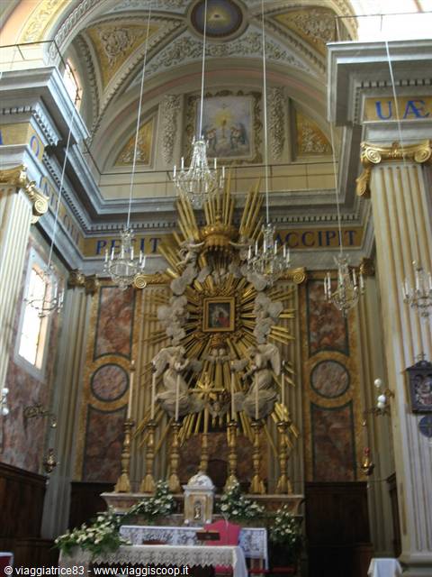 Gilded high altar with radiant sun rays and crystal chandeliers in baroque church