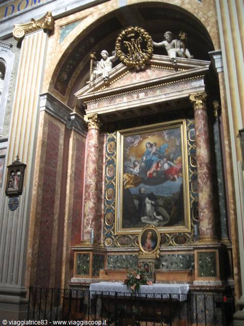 Polychrome marble altar with Marian painting, statues and columns inside a baroque church