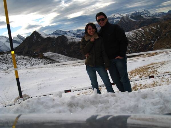 Smiling couple in jackets among snow and snowy peaks, Passo Pordoi, Dolomites