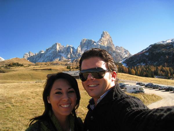 Smiling couple taking selfie in front of Pale di San Martino, Dolomites