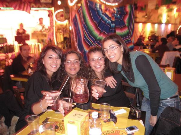 Four friends toast with sangria at a colorful Mexican restaurant table