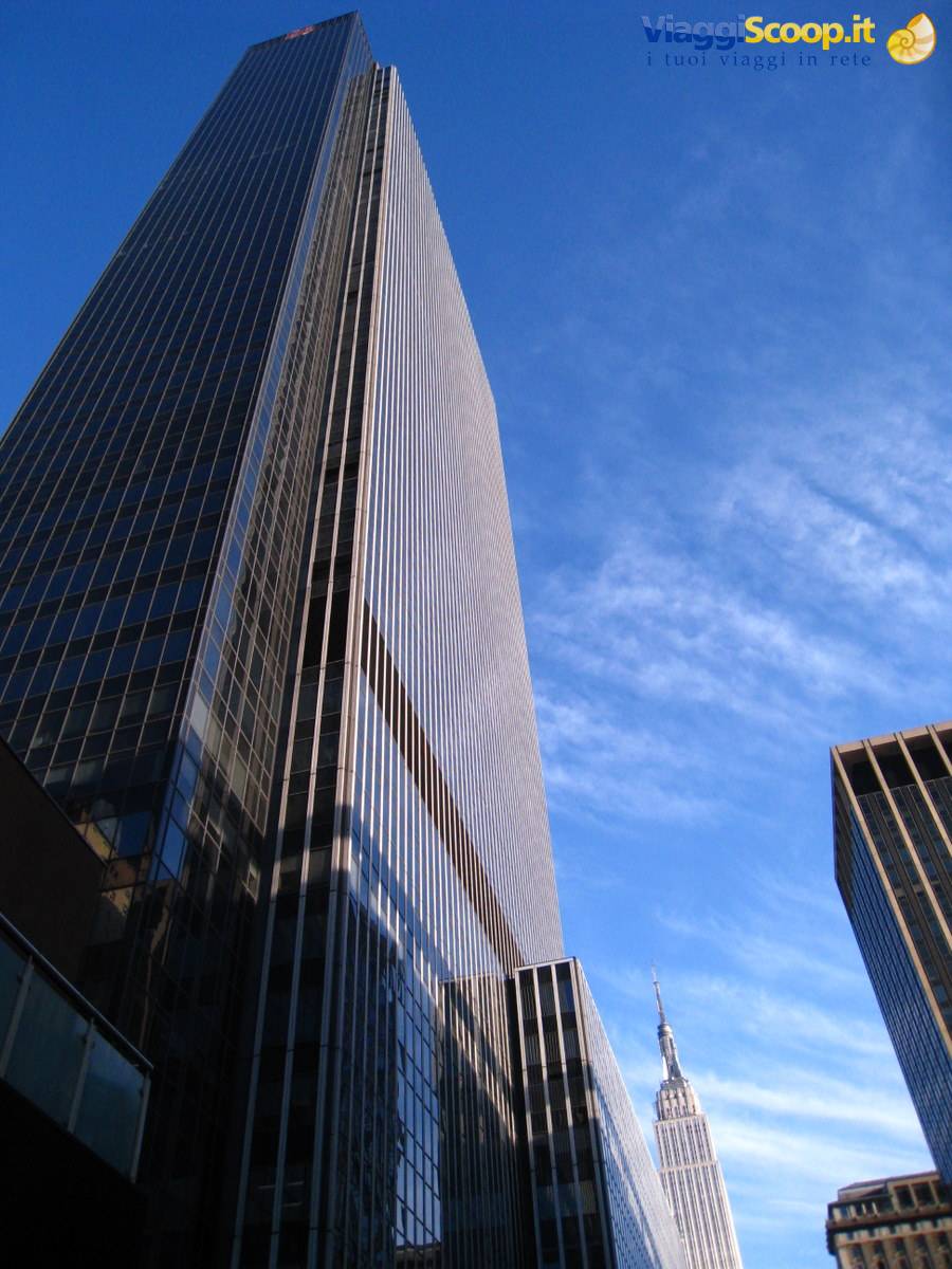 Glass skyscrapers in New York, the Empire State Building touched by clouds
