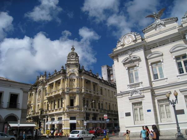 Eclectic yellow and white historic buildings under cloudy sky in Recife
