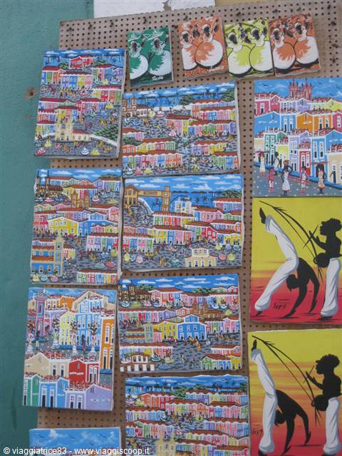Hand-painted tiles with colorful houses and capoeira art on display
