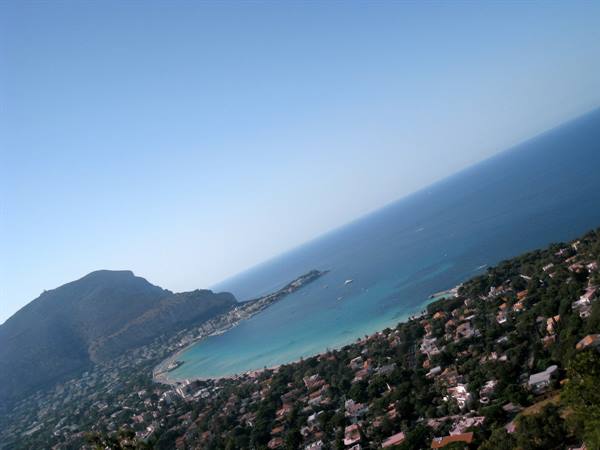 Gulf of Saint-Tropez: turquoise sea, red-roofed houses in bright sunlight