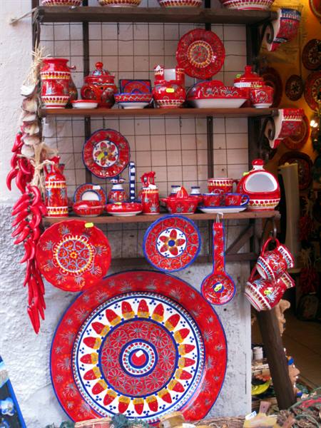 Hand-painted red ceramics and hanging chili peppers in an artisan shop