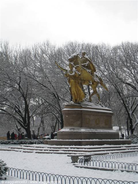 Snow-covered golden equestrian statue among bare trees, Central Park, New York