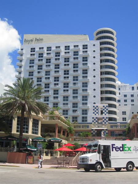 FedEx truck in front of the Royal Palm hotel with palms and red umbrellas
