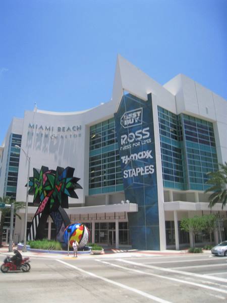 Miami Beach shopping center with Best Buy signs and colorful sculpture under sunny sky
