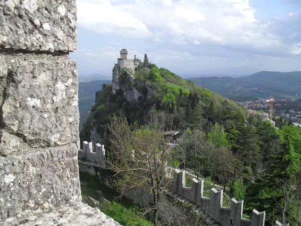 Guaita fortress atop green rock, stone crenellated walls, San Marino
