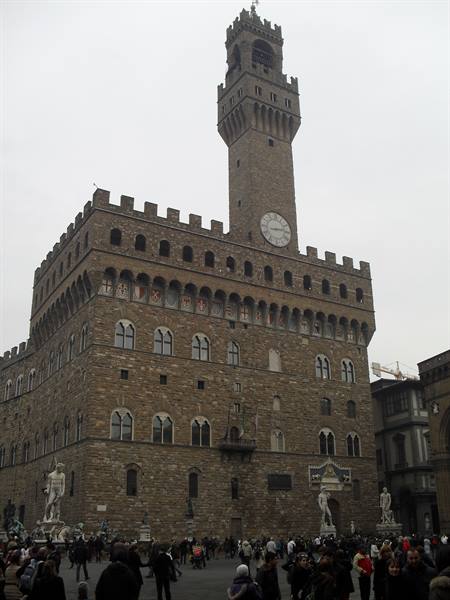 Palazzo Vecchio in Florence, crowd of tourists in the square under grey sky