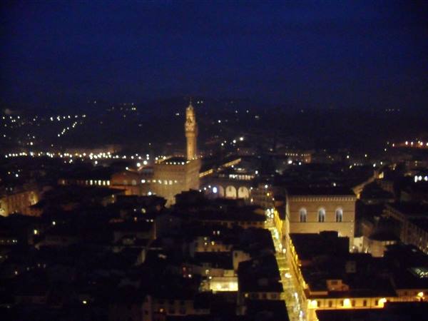 Palazzo Vecchio lit up at night above Florence rooftops