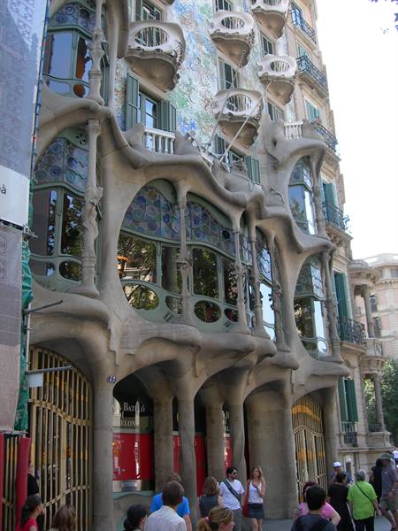 Tourists in front of Casa Batlló's undulating stone and glass facade in Barcelona