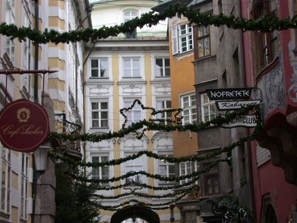 Café Sacher sign and Christmas garlands over an Innsbruck old street