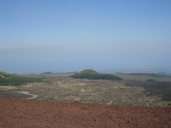 Volcanic cones and lava flows under the blue sky of Mount Etna