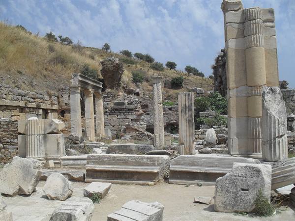 Broken marble columns among ancient ruins of Ephesus under a cloudy sky