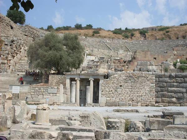 Ruins of Ephesus: stone walls, ancient columns and tourists near the theatre