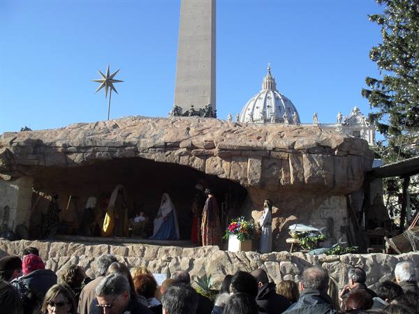 Nativity scene beneath St. Peter's obelisk and dome, crowd watching