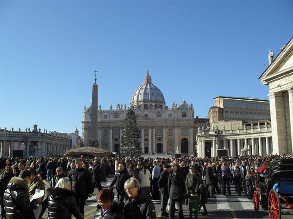 Crowd in St. Peter's Square, Rome, in winter cold with basilica in background