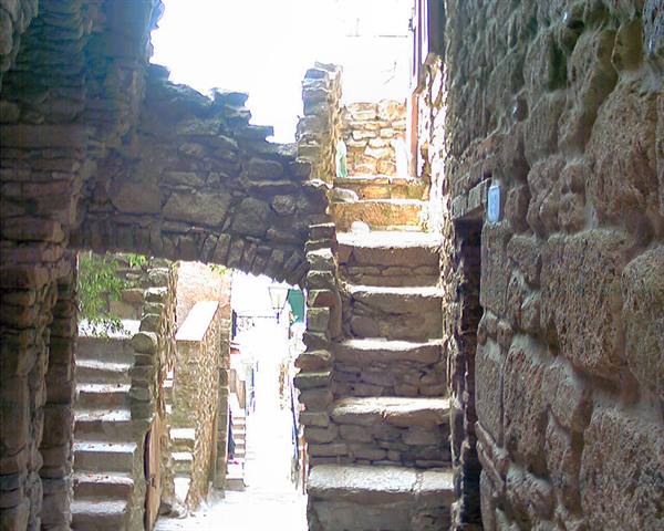 Stone staircase between ancient walls, sunlight on medieval alley