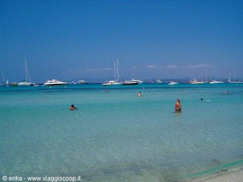 Swimmers in turquoise water with anchored yachts, Saline beach
