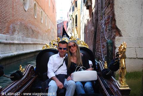 Couple on an ornate gondola gliding through a narrow Venice canal