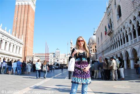 Smiling tourist in St Mark's Square, Venice, with bell tower and Doge's Palace