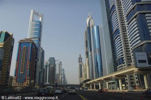 Glass skyscrapers along Sheikh Zayed Road in Dubai, traffic below the elevated metro