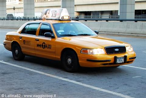 Yellow NYC Ford Crown Victoria taxi turning on a city street
