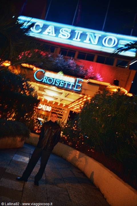 Tourist in leather jacket under the neon Casino Croisette sign at night