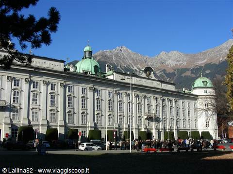 Innsbruck Hofburg, white facade with green domes, people and cars below the mountains