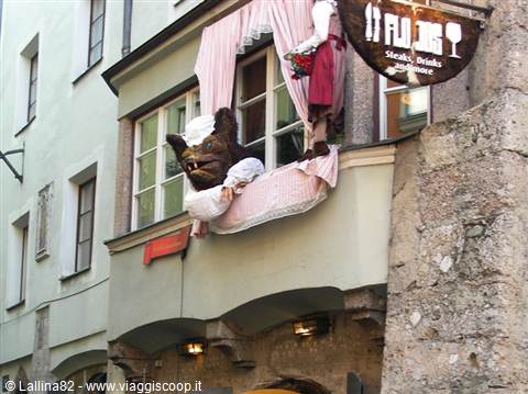 Flannigan's pub, a monster in a hat leans out the pink-draped window