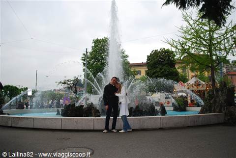 Couple kissing in front of the circular fountain with central jet in Lugano