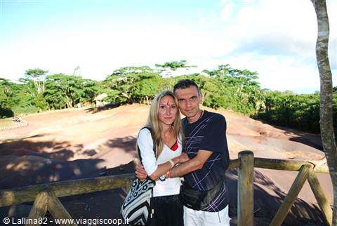 Couple embracing on wooden railing at Chamarel Seven Coloured Earths