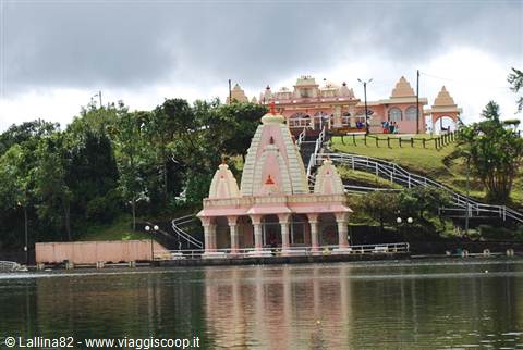 Pink Hindu temple on the sacred Ganga Talao lake in Mauritius, surrounded by trees