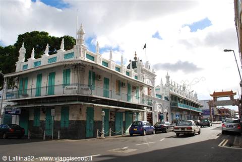 Jummah Mosque in Port Louis, white and turquoise facade among parked cars