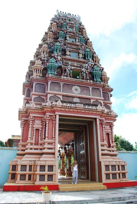 Tourist beneath the painted gopuram tower at Hindu temple entrance