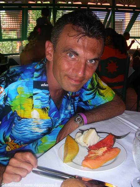 Smiling man in Hawaiian shirt in front of fresh fruit plate