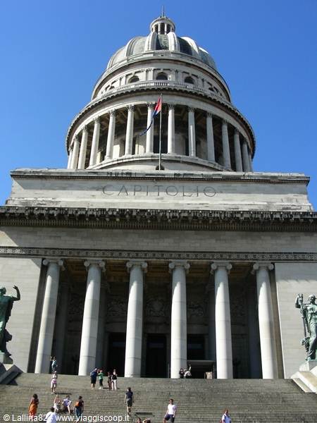 Tourists on the Capitolio steps in Havana, stone columns and dome under bright sun