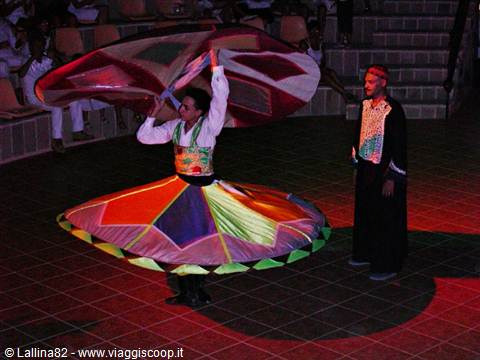 Tanoura dancer spins in colorful skirt, performer watching beside him