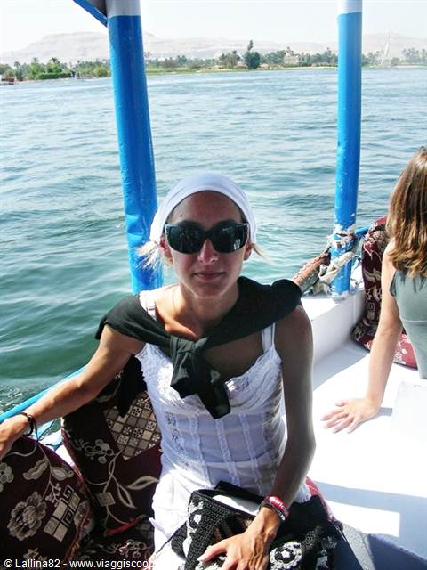Tourist in bandana and sunglasses aboard a felucca sailing the Nile at Aswan