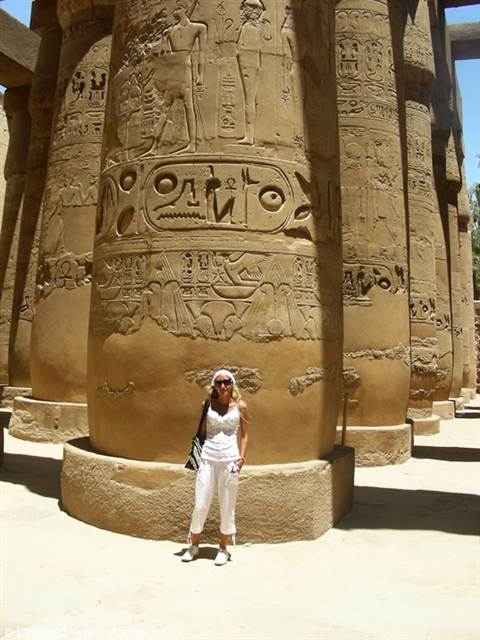 Tourist in white beside a giant hieroglyph-covered column, Karnak temple
