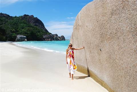 Tourist beside a huge granite boulder on Anse Source d'Argent beach