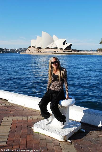 Girl sitting on a white bollard, Sydney Opera House in the background