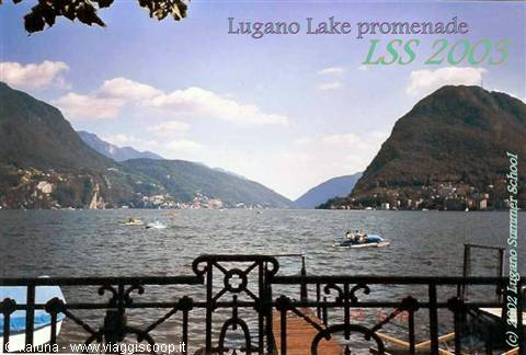 Lugano: wrought iron railing on the promenade, pedal boats on the lake