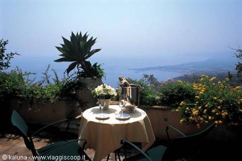 Champagne table on flowered terrace above the sea, Taormina