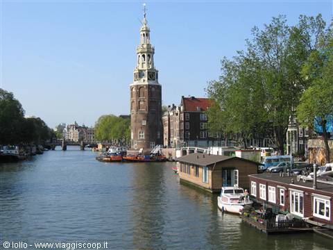 Houseboat on the canal with the Montelbaanstoren tower in Amsterdam
